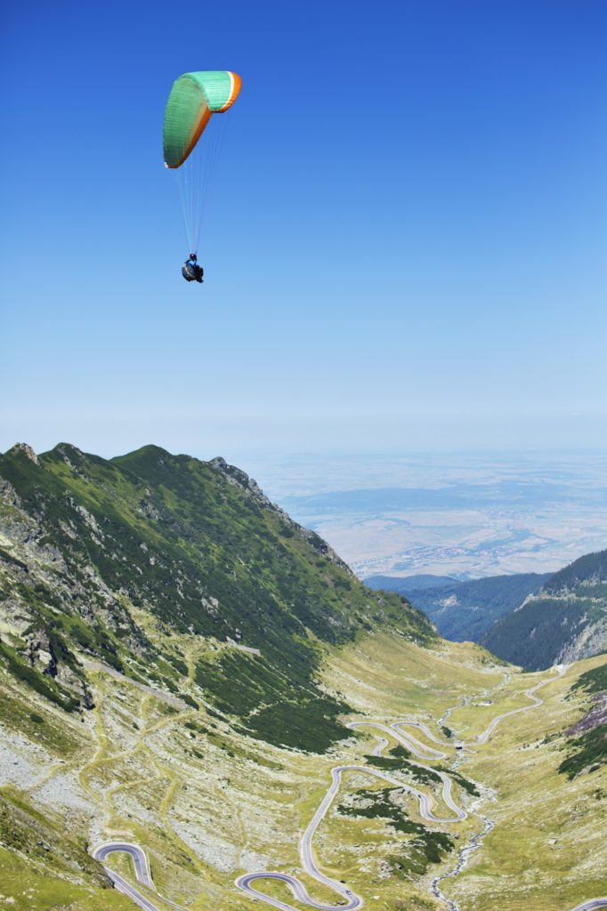 Man Paragliding Above Mountains