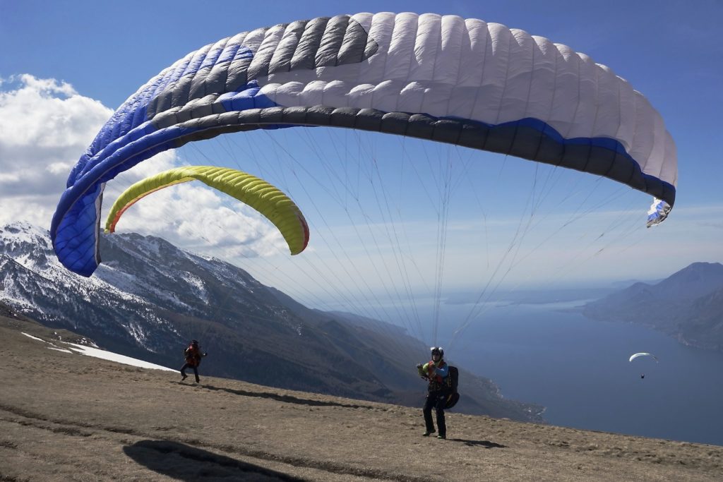 Paragliders starting in front of Lake Garda